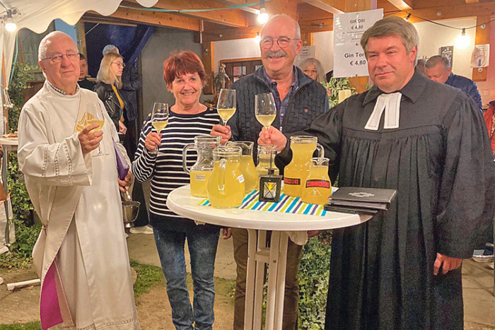 Dietlinde und Reinhard Koch (Mitte) mit Diakon Alfred Resetar und Pfarrer Carsten Max – mit einem Glas Jungwein nach der Taufe.